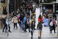 People wearing face mask walk along Bourke Street Mall in Melbourne, Friday, Nov. 6, 2020. Australia’s highest court on Friday upheld a state’s border closure and dismissed billionaire businessman Clive Palmer’s argument that the pandemic measure was unconstitutional.(James Ross/AAP Images via AP)