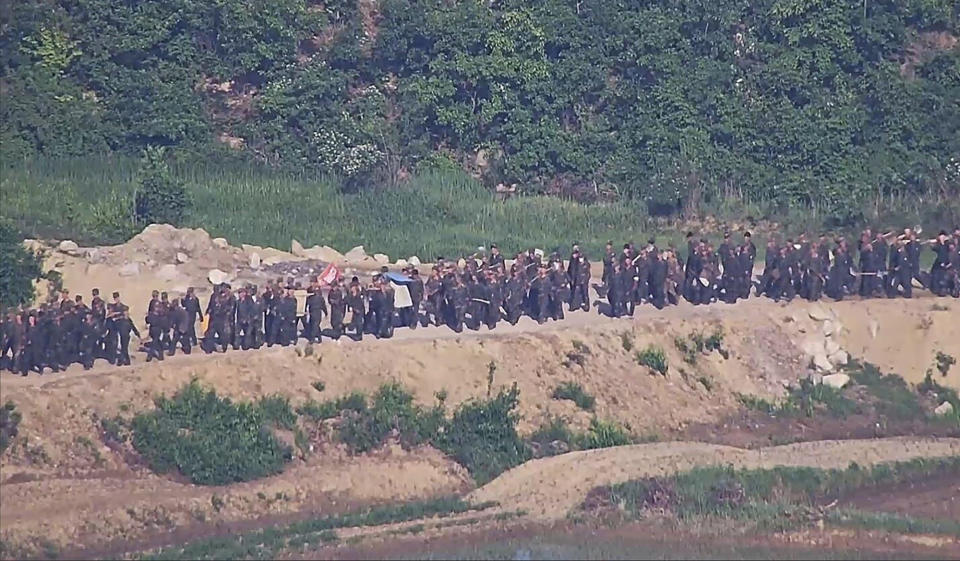 In this undated photo provided on Tuesday, June 18, 2024, by South Korea Defense Ministry, North Korean soldiers work at an undisclosed location near the border area, as seen from a South Korean guard area. South Korean soldiers fired warning shots to repel North Korean soldiers who temporarily crossed the rivals' land border Tuesday for the second time this month, South Korea's military said. (South Korea Defense Ministry via AP)