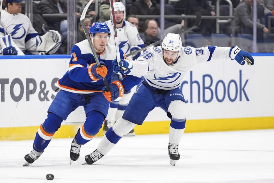 Tampa Bay Lightning's Brandon Hagel (38) fights for control of the puck with New York Islanders' Mathew Barzal (13) during the first period of an NHL hockey game Saturday, Feb. 24, 2024, in Elmont, N.Y. (AP Photo/Frank Franklin II)