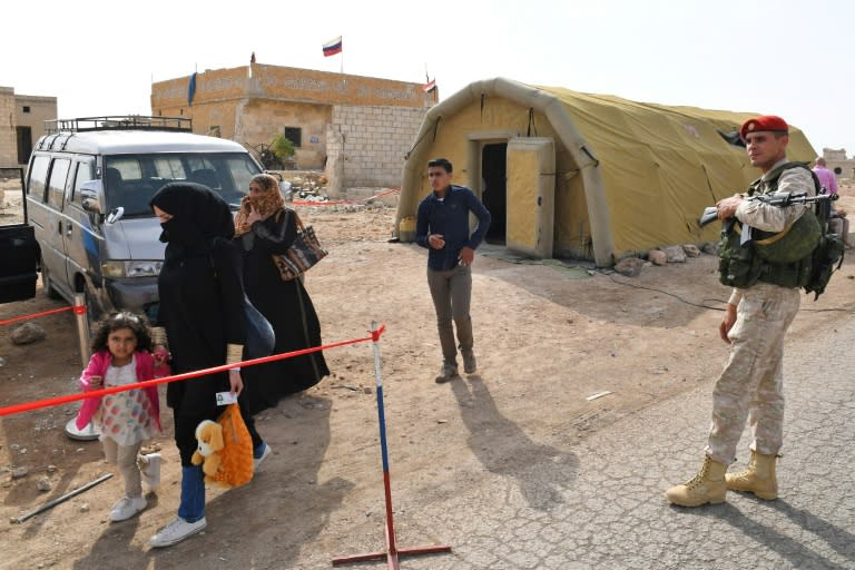 Russian and Syrian troops oversee the passage of civilians through the Abu Duhur crossing at the eastern edge of the planned buffer zone around rebel territory in Idlib on October 23, 2018