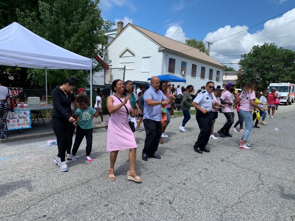 Sabina Matos dances the electric slide while campaigning at the Pearl Street Block Party in Upper South Providence.