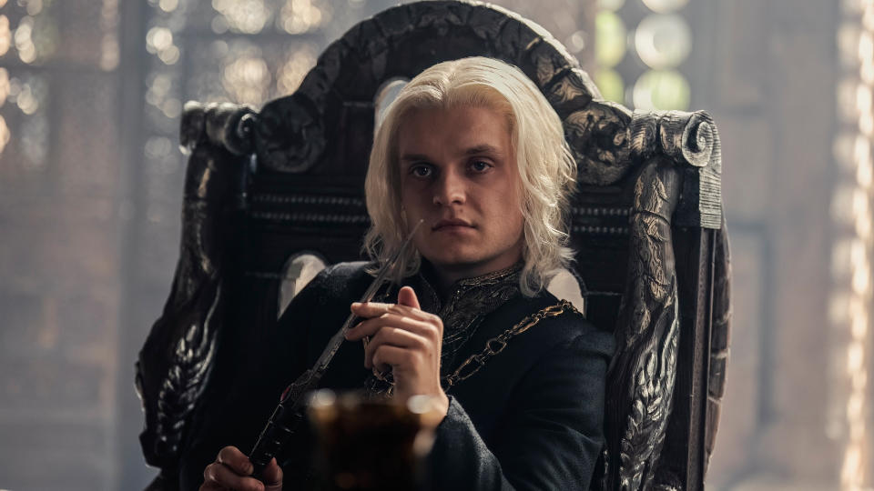 Aegon II (Tom Glynn-Carney) sitting in a chair in the Small Council room in 