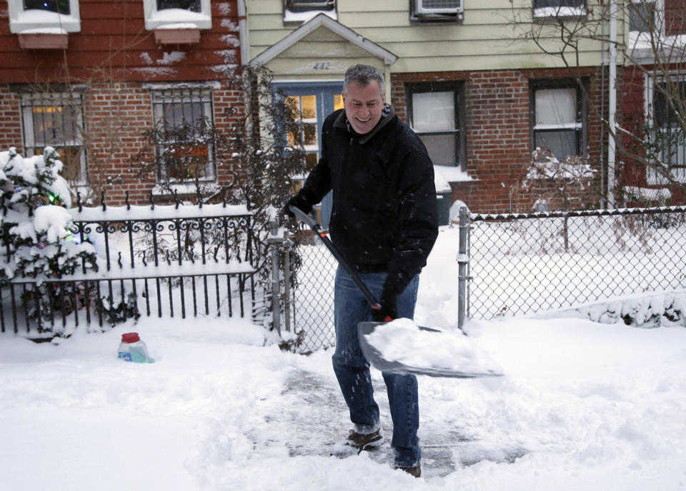 FILE - In this Jan. 3, 2014, file photo, New York City Mayor Bill de Blasio shovels the sidewalk in front of his house in New York. De Blasio's first 100 days as mayor of New York were marked in nearly equal measures by accomplishing campaign goals and committing political blunders. The mayor's managerial skills were called into question after he was forced to admit that the city did not plow several neighborhoods effectively during one of the winter’s many snowstorms. (AP Photo/Seth Wenig, File)