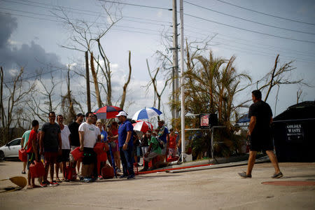 FILE PHOTO: People queue to fill container with gasoline in a gas station after the area was hit by Hurricane Maria in Toa Baja, Puerto Rico September 24, 2017. REUTERS/Carlos Garcia Rawlins/File Photo