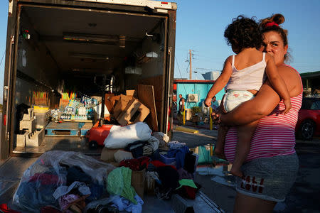 A woman and child wait to receive donated goods for Hurricane Irma victims in Marathon, Florida, U.S., September 18, 2017. REUTERS/Carlo Allegri