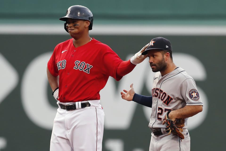 Boston Red Sox's Rafael Devers, left, interacts with Houston Astros' Jose Altuve, right, after hitting a double during the first inning of a baseball game, Wednesday, June 9, 2021, in Boston. (AP Photo/Michael Dwyer)