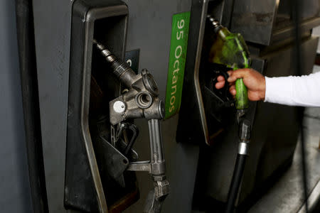A man handles the nozzle of a fuel dispenser at a state oil company PDVSA's gas station in Caracas, Venezuela May 17, 2019. REUTERS/Ivan Alvarado