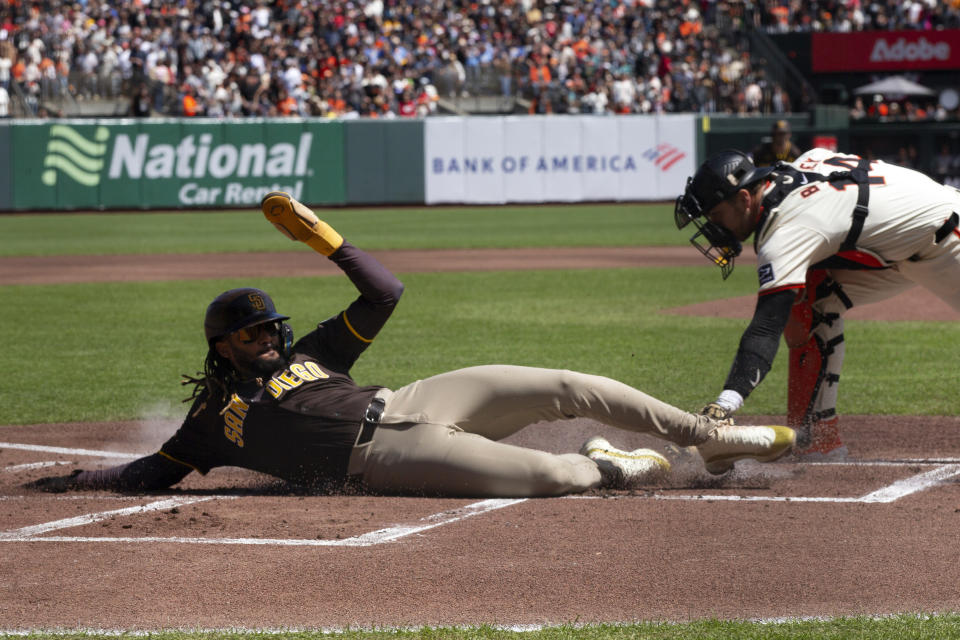 San Diego Padres' Fernando Tatis Jr., left, slides safely home ahead of the tag by San Francisco Giants catcher Patrick Bailey on a double by Jake Cronenworth during the first inning of a baseball game, Sunday, April 7, 2024, in San Francisco. (AP Photo/D. Ross Cameron)