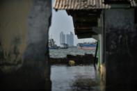 Ships are seen from an abandoned submerged mosque's walls in northern Jakarta