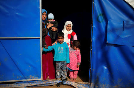 Displaced Iraqi Doha Ahmed, 29, poses for a photograph with her four children at Hammam al-Alil camp south of Mosul, Iraq, March 29, 2017. Ahmed's husband, a construction worker, is away looking for food. Ahmed said she has to search every morning milk and baby food for her children, aged between one and nine. She said the family and about 1,000 people from the same neighbourhood in Western Mosul flew together under mortar shelling just before sunrise. They walked until they reached checkpoints manned by the Iraqi army. From there, army trucks took them to the camp. REUTERS/Suhaib Salem SEARCH "DISPLACED REFUGE" FOR THIS STORY. SEARCH "WIDER IMAGE" FOR ALL STORIES.