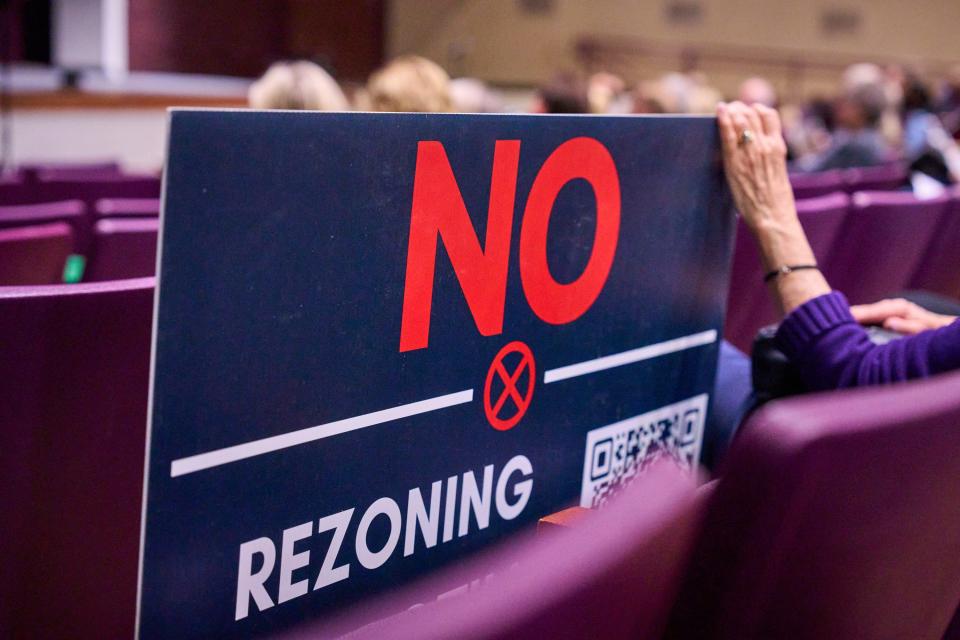 A Chandler resident holds a sign opposing rezoning on Ocotillo Road during a town-hall at Hamilton High School in Chandler, on Wednesday, Jan. 25, 2023.