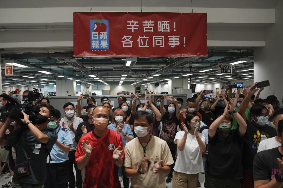 Staff members gather at the Apple Daily headquarters in Hong Kong, Wednesday, June 23, 2021. Hong Kong's pro-democracy Apple Daily newspaper will stop publishing Thursday, following last week's arrest of five editors and executives and the freezing of $2.3 million in assets under the city's one-year-old national security law. (AP Photo/Kin Cheung)