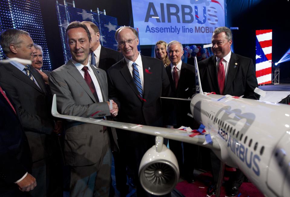 Airbus President & CEO Fabrice Bregier, second from left, shakes hands with Alabama Gov. Robert Bentley as they pose with a model of the A320 Airbus following an announcement that Airbus will establish its first assembly plant in the United States in Mobile, Ala., Monday, July 2, 2012. The French-based company said the Alabama plant is expected to cost $600 million to build and will employ 1,000 people when it reaches full production, likely to be four planes a month by 2017. (AP Photo/Dave Martin)