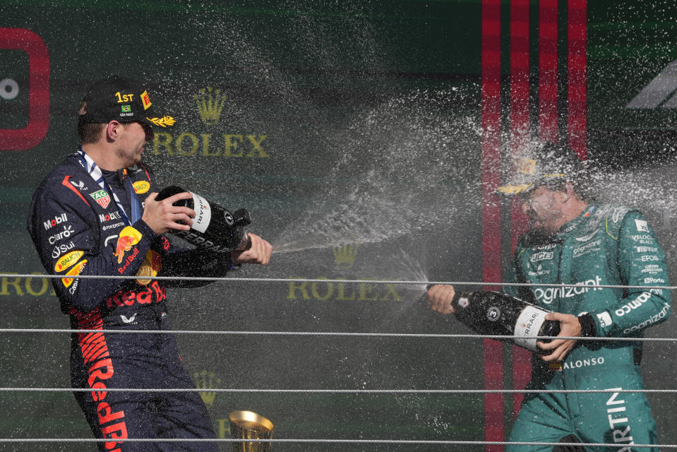 Winner Red Bull driver Max Verstappen of the Netherlands, left, sprays champagne on the podium with third place Aston Martin driver Fernando Alonso of Spain at the end of the Brazilian Formula One Grand Prix at the Interlagos race track in Sao Paulo, Brazil, Sunday, Nov. 5, 2023. (AP Photo/Andre Penner)