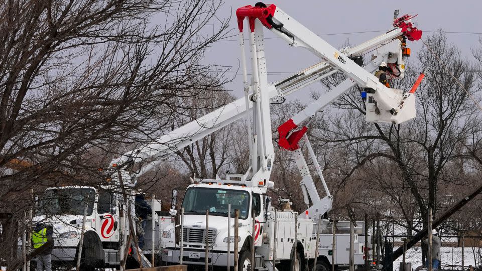 Utility workers from Xcel Energy labor on power lines near a home destroyed by the Smokehouse Creek fire, on February. 29 in Stinnett, Texas. - Julio Cortez/AP