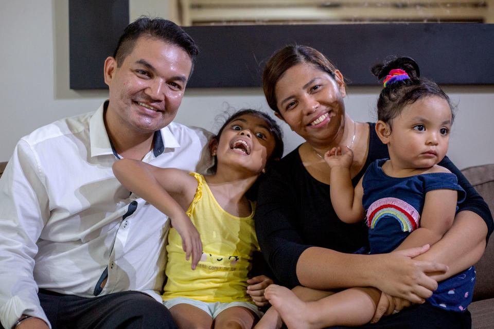 Bereaved parents Muhammad Reeza, 40, and Fazilah Kamaruddin, 37, pose in their Pasir Ris flat with two of their children Ely Aaryza, 8, and Eryn Falisha, one and a half. PHOTO: Dhany Osman/Yahoo News Singapore