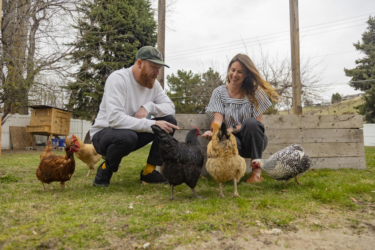 Aaron and Carrie Friesen feed chickens in the backyard of their home in Boise, Idaho, on April 12, 2023. The couple, who has three children, recently moved to Idaho from the Bluffton, S.C., area. (AP Photo/Kyle Green)