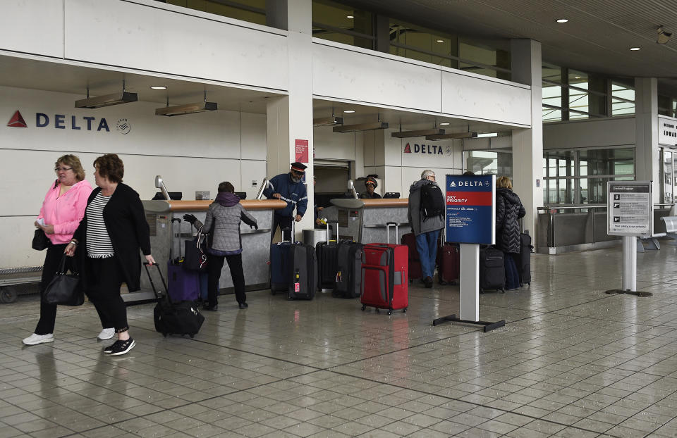 People walk by the Detroit Metro Airport in Romulus, Mich., Wednesday, Jan. 23, 2019, which was closed for hours. Detroit's main airport has reopened after icy weather prompted officials to shut down flights for about 14 hours amid freezing rain. (Clarence Tabb/Detroit News via AP)