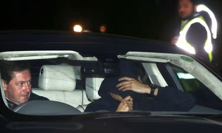 A man believed to be Jose Mourinho covers his face under a hoody as he is is driven out of Chelsea's training, in Cobham southern England, December 17, 2015. REUTERS/Peter Nicholls