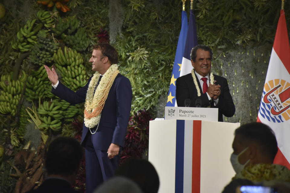 France's President Emmanuel Macron wearing a flower lei and seashell necklaces and French Polynesia Edouard Fritch acknowledge applauses after their speeches in Tahiti, French Polynesia in the Pacific Ocean, Tuesday, 27, 2021.President Emmanuel Macron reasserted France's presence in the Pacific on a visit to French Polynesia aimed in part at countering growing Chinese dominance in the region. (AP Photo/Esther Cuneo)