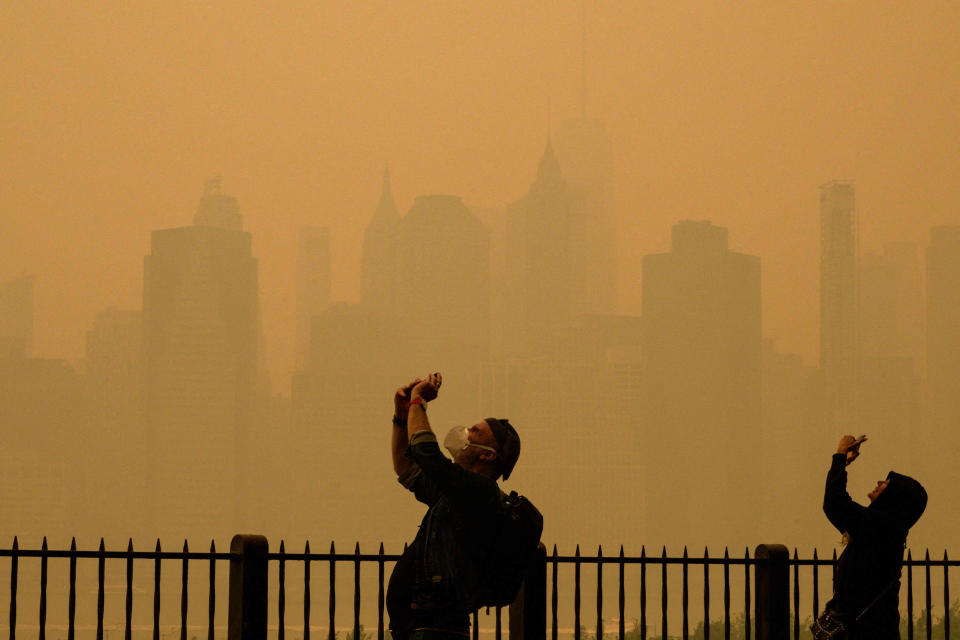 People take photos of the sun as smoke from the wildfires in Canada cause hazy conditions in New York City on June 7, 2023.  (Angela Weiss / AFP - Getty Images)