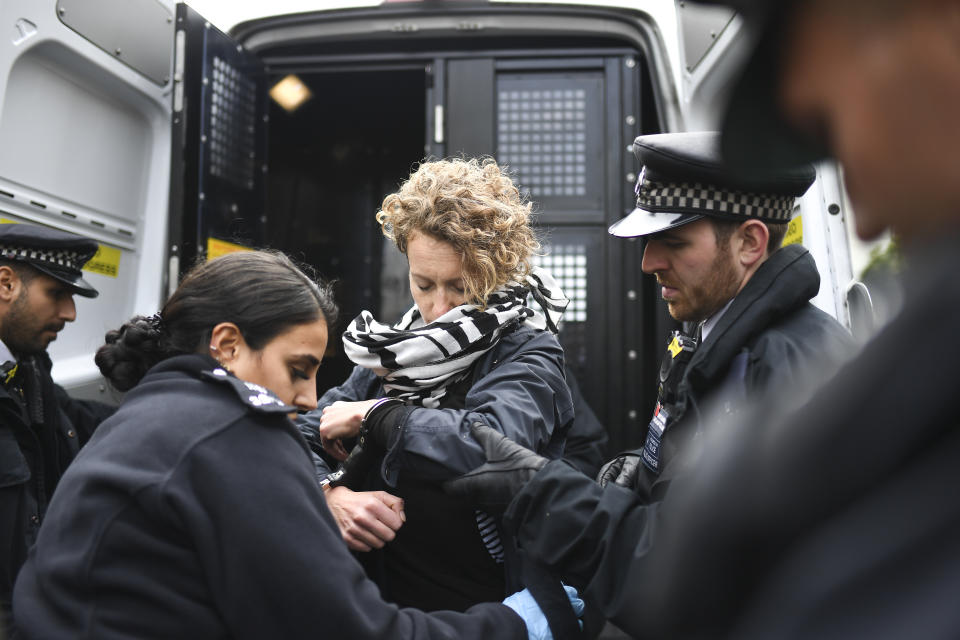 Police officers arrest a demonstrator during an Extinction Rebellion Protest in London, Monday, Oct. 7, 2019. (Photo: Alberto Pezzali/AP)