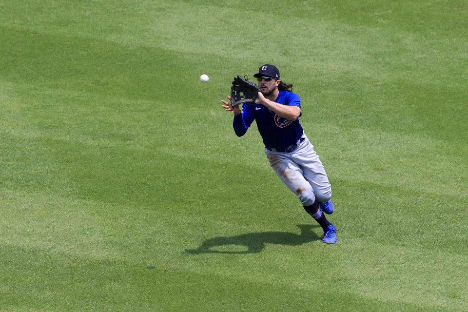 Chicago Cubs' Jake Marisnick (6) fields a fly ball for an out hit by Cincinnati Reds' Tyler Naquin during the fourth inning of a baseball game in Cincinnati, Sunday, July 4, 2021. (AP Photo/Aaron Doster)