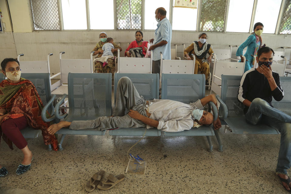 People wearing face masks as a precaution against the coronavirus wait for doctor consultation at a government hospital in Jammu, India, Monday, June 21, 2021. (AP Photo/Channi Anand)