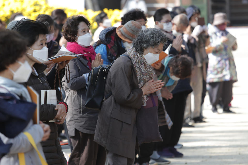 People wearing face masks to help curb the spread of the coronavirus pray during a service at the Chogyesa temple in Seoul, South Korea, Monday, Oct. 19, 2020. South Korea on Monday began testing tens of thousands of employees of hospitals and nursing homes to prevent COVID-19 outbreaks at live-in facilities. (AP Photo/Ahn Young-joon)