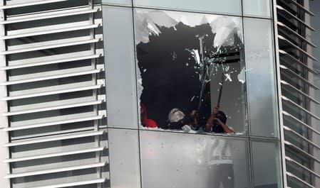 Manifestantes destrozan el ventanal de un edificio del gobierno durante una protesta contra las medidas de austeridad del presidente de Ecuador, Lenín Moreno, en Quito, Ecuador. 12 de octubre de 2019.