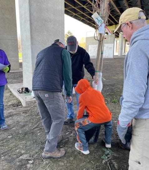 People help with tree planting April 30 at Port Dickinson Community Park as Fr. Tim Taugher, right, looks on.