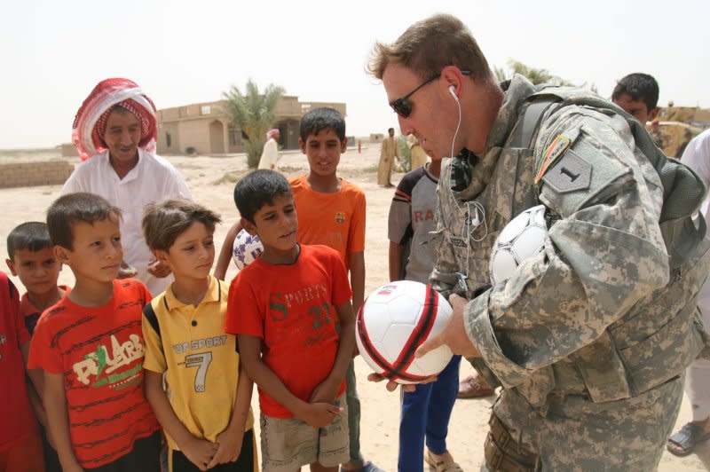 A U.S. soldier hands out toys to children in Diyala province, 65 kilometers north of Baghdad on August 14, 2008. On November 24, 2007, a brigade of 5,000 U.S. troops left Diyala province in Iraq. It was considered the first significant pullback of American forces from the country. File Photo by Ali Jasim/UPI