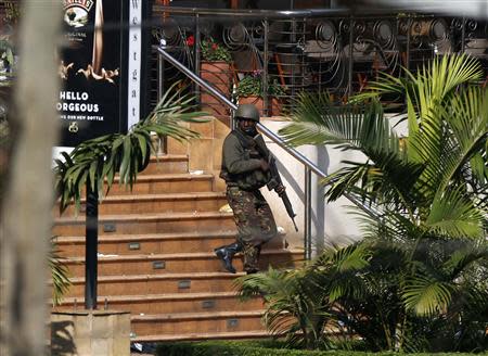 A Kenyan soldier walks out of the main gate of Westgate Shopping Centre in Nairobi September 22, 2013. REUTERS/Goran Tomasevic