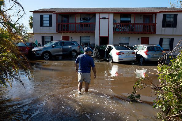 FORT MYERS, FLORIDA - SEPTEMBER 30: Omar Sanchez walks through flood waters to his apartment after Hurricane Ian passed through the area on September 30, 2022 in Fort Myers, Florida.  Mr. Sanchez said he had to flee from his first floor apartment to the second floor because flood waters inundated it. The hurricane brought high winds, storm surges and rain to the area causing severe damage. (Photo by Joe Raedle/Getty Images)