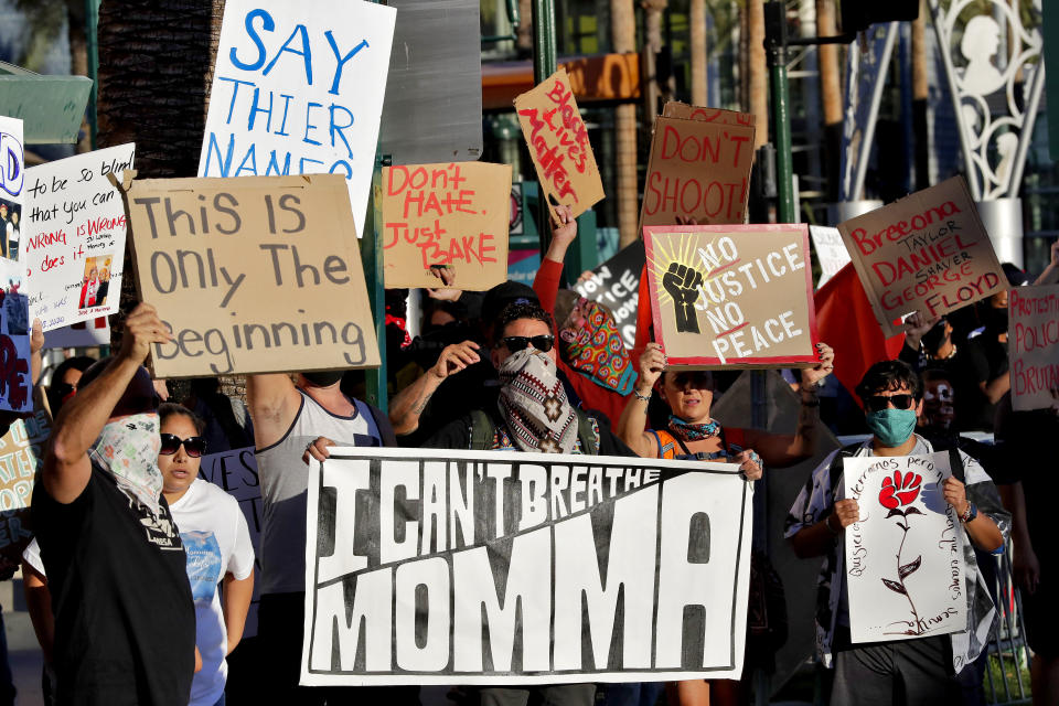 Protesters rally Tuesday, June 9, 2020, in Mesa, Ariz. demanding police reform. The protest was prompted by the death of George Floyd, a black man who died after being restrained by Minneapolis police officers May 25. (AP Photo/Matt York)