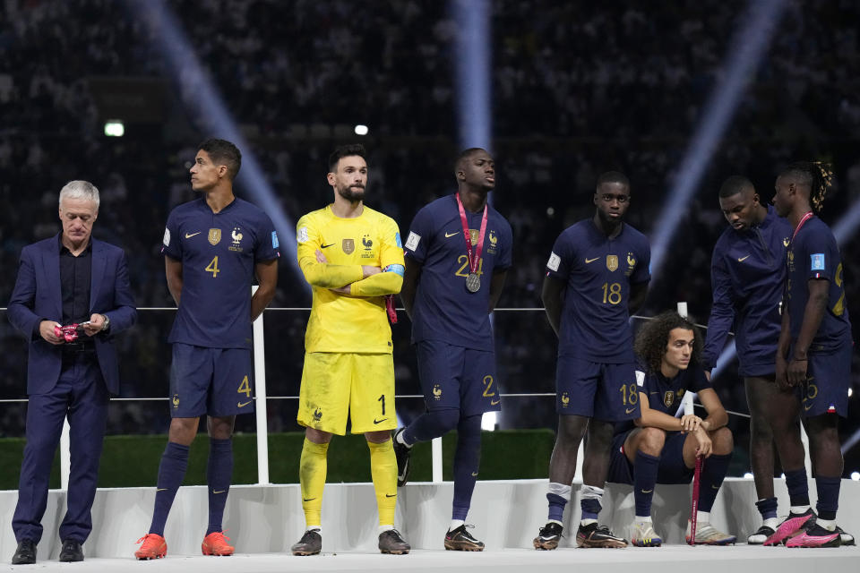 France's head coach Didier Deschamps, left, and his players react after receiving their second place medals at the end of the World Cup final soccer match between Argentina and France at the Lusail Stadium in Lusail, Qatar, Sunday, Dec. 18, 2022. Argentina won 4-2 in a penalty shootout after the match ended tied 3-3. (AP Photo/Martin Meissner)