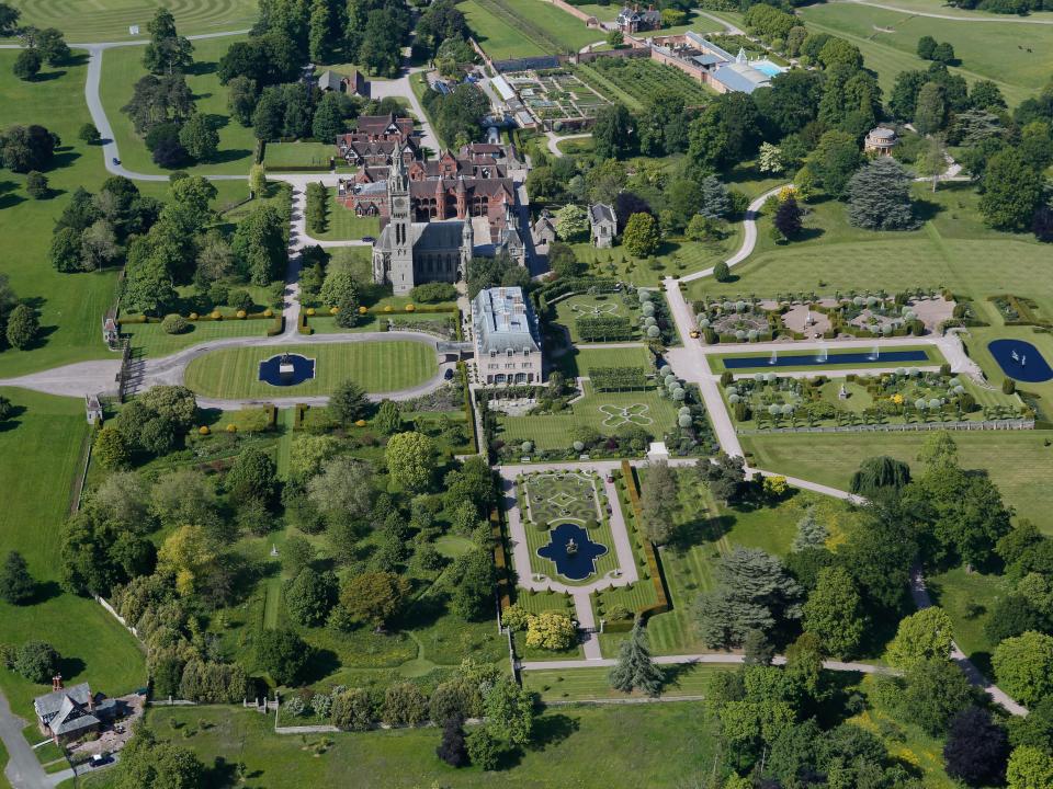 A view over the grounds of Eaton Hall in Cheshire, with several large lawns, trees, and buildings.