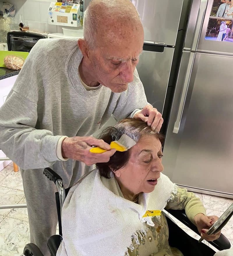 The caring husband is a picture of focus as he colours his wife’s hair. — Picture via Facebook/American Salon