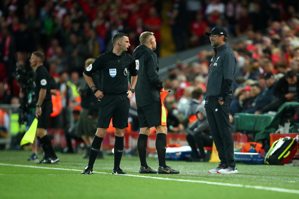 LIVERPOOL, ENGLAND - AUGUST 09: The referee and match officials have issues with their communication head sets before the start of the second half during the Premier League match between Liverpool FC and Norwich City at Anfield on August 9, 2019 in Liverpool, United Kingdom. (Photo by Robbie Jay Barratt - AMA/Getty Images)