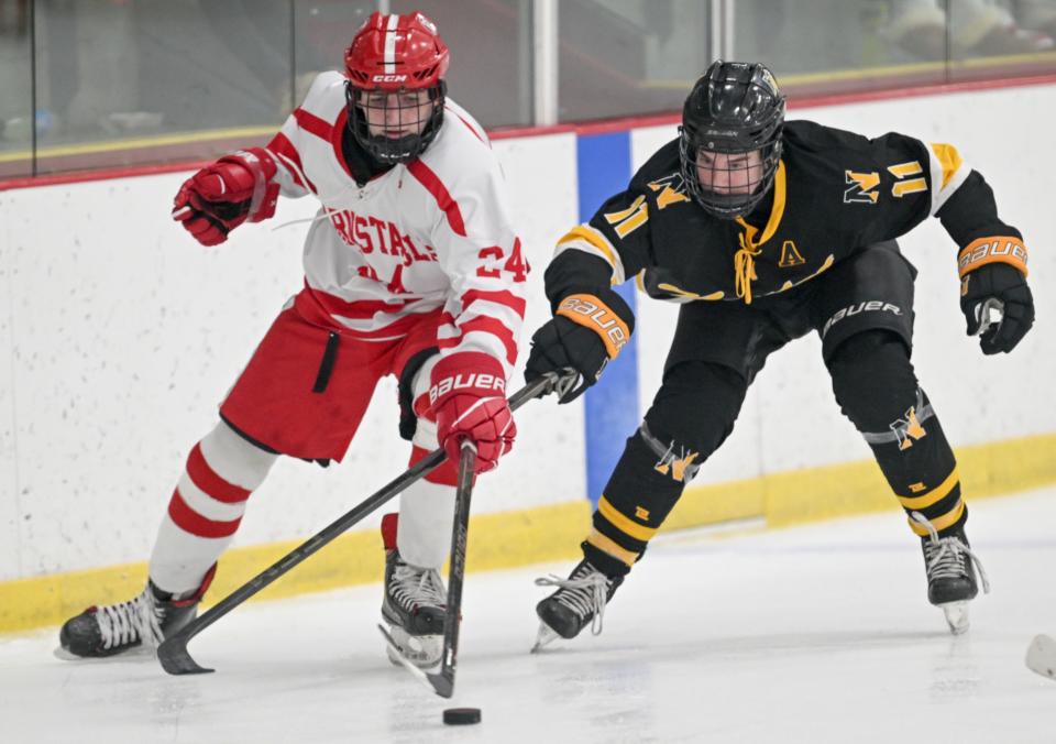 Cam Connery of Nauset and Luke Harmon of Barnstable reach for the puck.