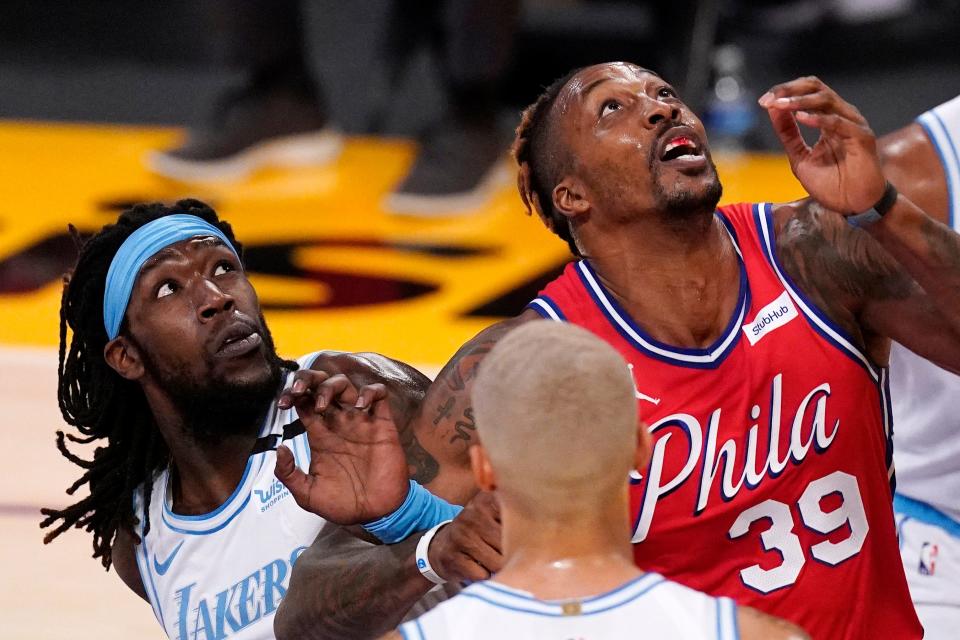 Los Angeles Lakers center Montrezl Harrell, left, and Philadelphia 76ers center Dwight Howard battle for a rebound during the first half of an NBA basketball game Thursday, March 25, 2021, in Los Angeles. (AP Photo/Mark J. Terrill)