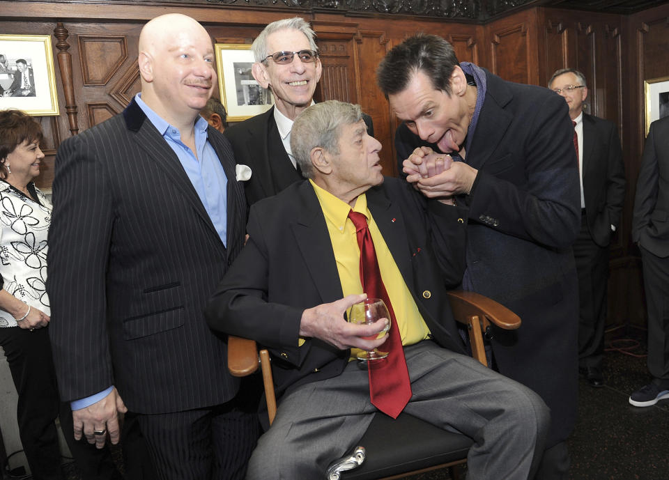 FILE - Jeff Ross, from left, Richard Belzer, and Jim Carrey, right, joke with entertainer Jerry Lewis at the Friars Club before his 90th birthday celebration on Friday, April 8, 2016, in New York. Belzer, the longtime stand-up comedian who became one of TV's most indelible detectives as John Munch in “Homicide: Life on the Street” and “Law & Order: SVU,” has died at age 78. Belzer died Sunday, Feb. 19, 2023, at his home in Bozouls in southern France, his longtime friend Bill Scheft told The Hollywood Reporter.(Photo by Brad Barket/Invision/AP, File)