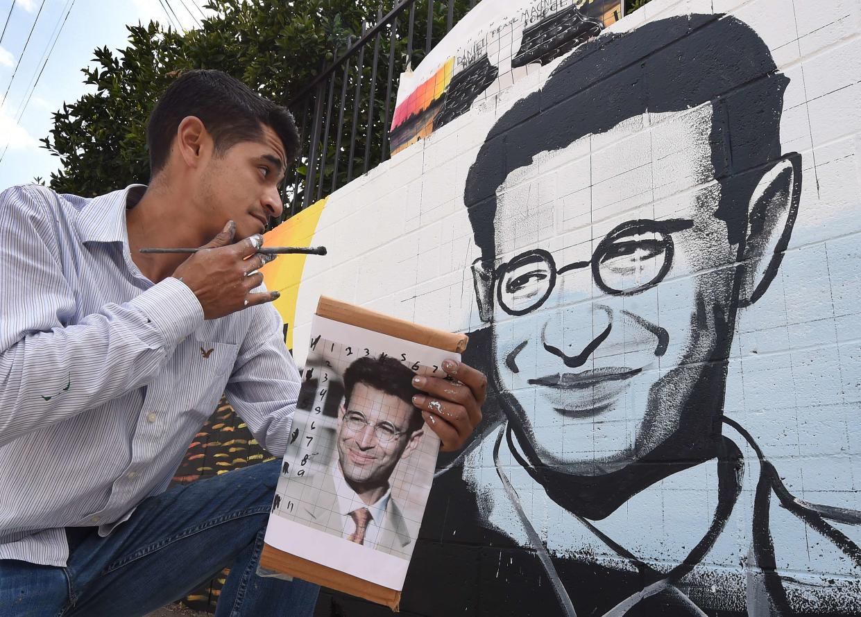 Artist Levi Ponce poses with his Memorial Day mural project of murdered journalist Daniel Pearl, near his old neighborhood in Los Angeles, California on May 23, 2015. Pearl was a Wall Street Journal reporter who was kidnapped and murdered by a terrorist group in Pakistan in 2002 while doing an investigative story. The artist is working with students from the Daniel Pearl High School and LAPD West Valley Police cadets on the project.