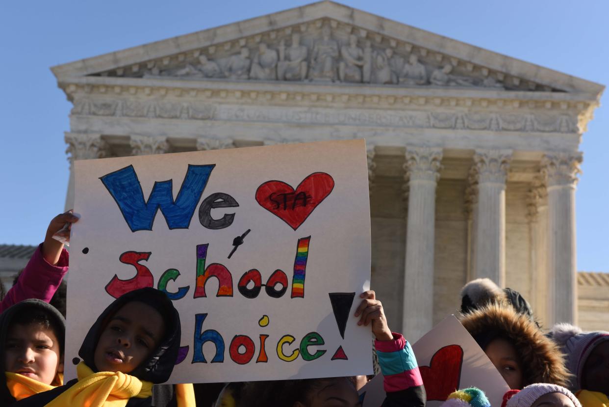 A sign held outside the Supreme Court as it heard arguments in a school choice case in 2020 in Washington.