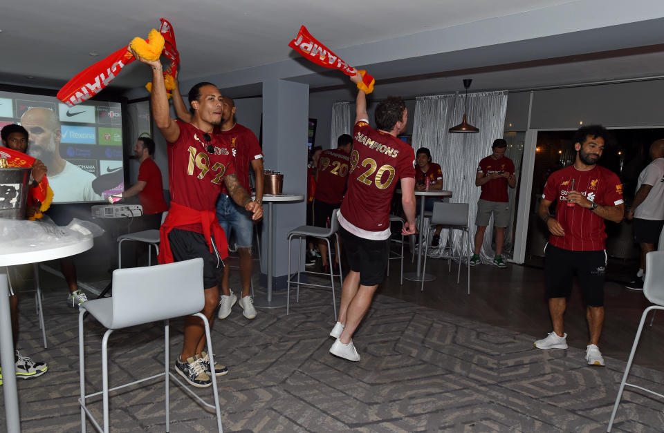 (Left to right) Virgil van Dijk, Andy Robertson and Mohamed Salah celebrate after Liverpool clinched the Premier League title. (Photo by Liverpool FC/Liverpool FC via Getty Images)