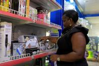 Yetunde Oluyide, Chief Executive Officer of Yetty-Jewel Ventures arranges items on the shelf in her store in Lagos