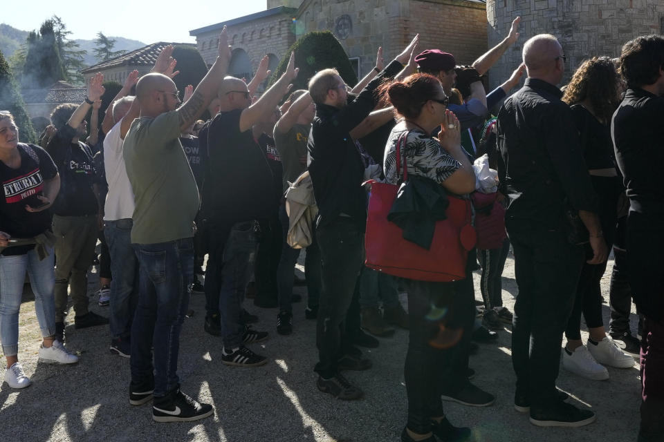 People perform a roman salute in the hometown of former dictator Benito Mussolini to mark the 100th anniversary of the coup d'etat by which he sized power in 1922, in Predappio, Italy, Sunday, Oct. 30, 2022. (AP Photo/Luca Bruno)