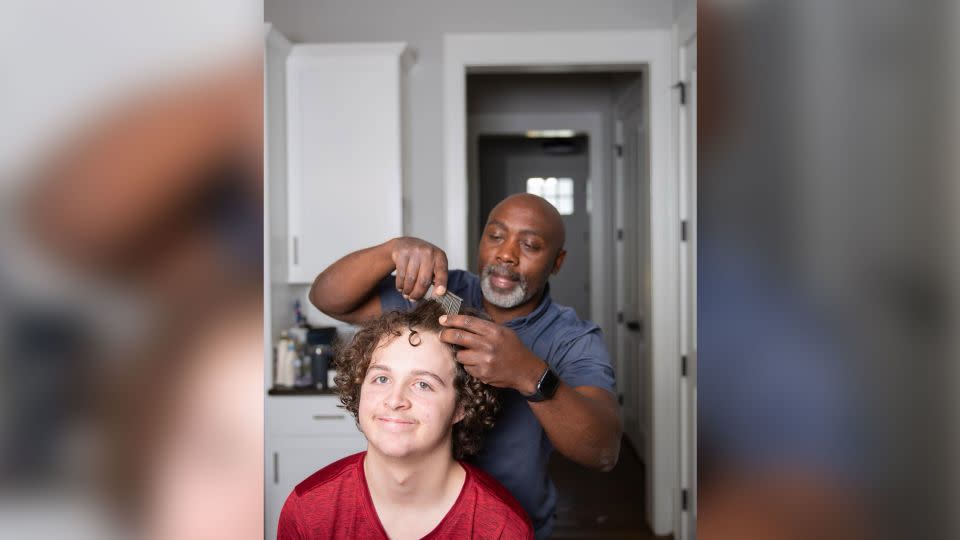 Mutabazi gives his oldest son Anthony a haircut. "Simple things go a long way to show someone you see them and you care," he says. - Courtesy Peter Mutabazi