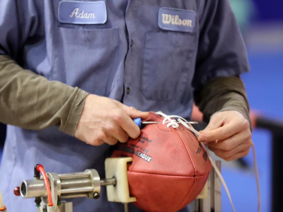 Adam, from the Wilson football factory in Ada, Ohio, laces a football.