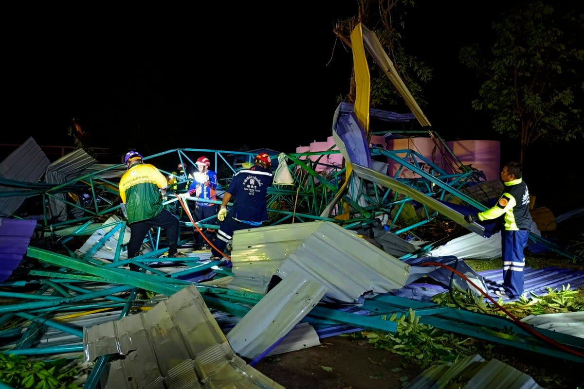 Thai rescue workers at the scene of a collapsed metal roof on a structure at the Wat Nern Por primary school in Phichit, Thailand  (Associated Press)